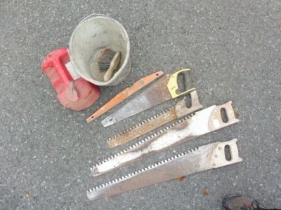 cinq types de scies différents posés par terre