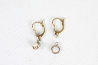 two pairs of gold hoop earrings with pearls on them