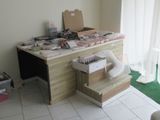 un bureau encombré d'objets, dans une pièce