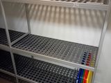 a metal shelf that has a bunch of colored pencils on it