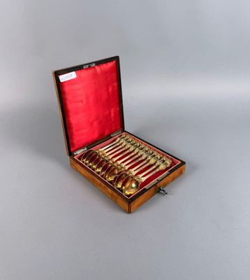 un coffret en bois contenant un service de cuillères en or