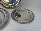 three silverplated dishes on a white table with a silver lid