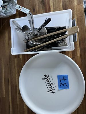 une assiette blanche sur laquelle sont posées des cuillères et des fourchettes