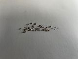 a lot of tiny pieces of metal on a white surface