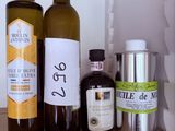 des bouteilles d'huile d'olive et d'autres ingrédients sur une étagère dans une cuisine