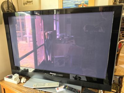 une télévision à écran plat posée sur une table en bois