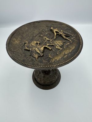 une image représentant une plaque en bronze sur laquelle figurent un cheval et un cavalier