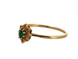 a close up of a gold ring with a green stone