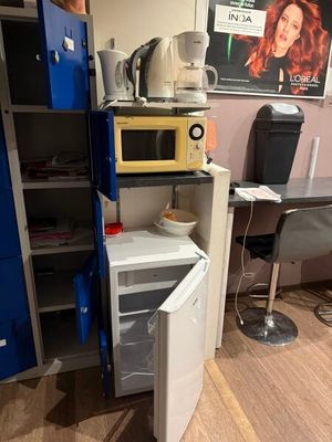un petit réfrigérateur dans un coin de la pièce