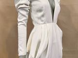 the mannequin is wearing a white dress with long sleeves
