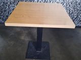 rectangular wooden table with black metal base in a room