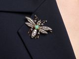 a close up of a person wearing a suit and a broochet