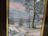 two framed paintings of a snowy landscape with a bench and tree