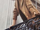 a woman that is standing on the balcony of a building
