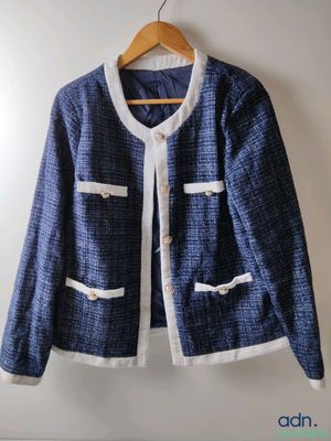 blue and white jacket hanging on a hanger on a wall