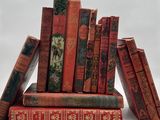 plusieurs vieux livres sont empilés sur une surface blanche