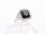 a close up of a ring with a black stone surrounded by white diamonds