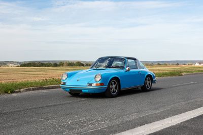 a blue car that is driving down the road