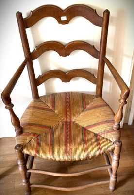 une chaise en bois dont l'assise et le dossier sont rayés