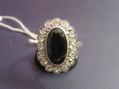 an image of a ring with a large black stone surrounded by small white diamonds