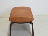 a small brown ottoman sitting on a white floor