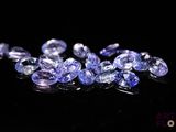 un tas de pierres précieuses de tanzanite sur une surface noire