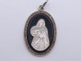 an oval silver and black glass pendant with a woman holding a child