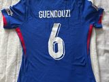 un gros plan sur un maillot de foot posé sur un lit