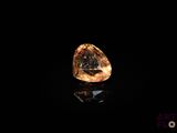 un diamant jaune dans l'obscurité, dont la surface reflète la lumière