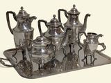 a silver tray with a silver tea set on it