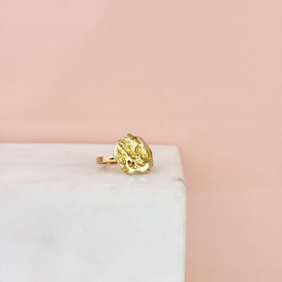a close up of a yellow diamond ring on a marble block