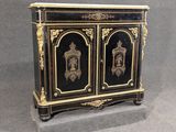 une armoire peinte en noir et or, à deux portes