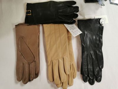 trois paires de gants en cuir sont alignées sur une surface blanche