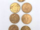 a group of five different coins sitting on top of a white surface