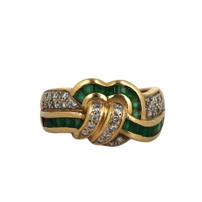 a close up of a gold ring with green and white stones