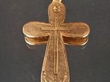 croix plaquée or sur une surface noire avec un fond noir