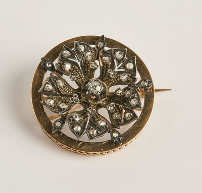 gros plan d'une broche en or sur une surface blanche