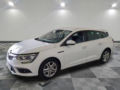 la voiture blanche est garée sur un sol en damier dans le garage