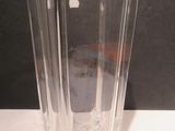 un vase en verre transparent posé sur une table, sur fond noir