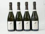 quatre bouteilles de vin sont alignées sur une surface blanche