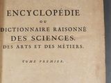 un vieux livre posé sur une table couverte d'écritures
