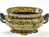 un bol vert et marron posé sur une table blanche