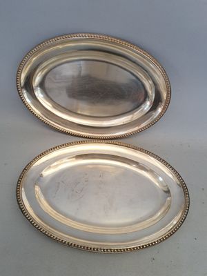 deux plateaux en argent posés l'un à côté de l'autre sur une table
