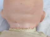 a baby doll with a dummy on a white surface