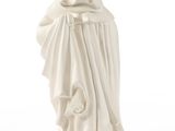 La statue d'une femme vêtue d'une robe blanche tient un chat dans ses bras.