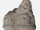 a stone sculpture of a man and a woman on a rock