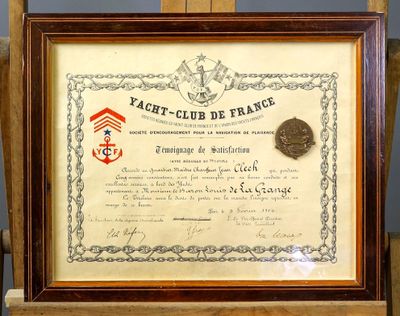 un vieux certificat encadré, accompagné d'une médaille, posé sur une chaise en bois