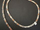 a close up of a silver and gold bracelet on a black surface