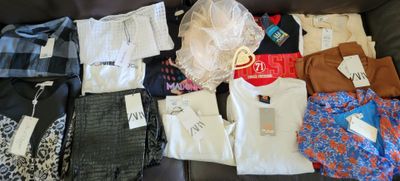 a lot of clothes that are sitting on a couch