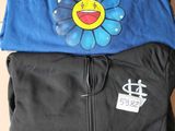 two t - shirts with a smiley face on them sitting on top of a cardboard box